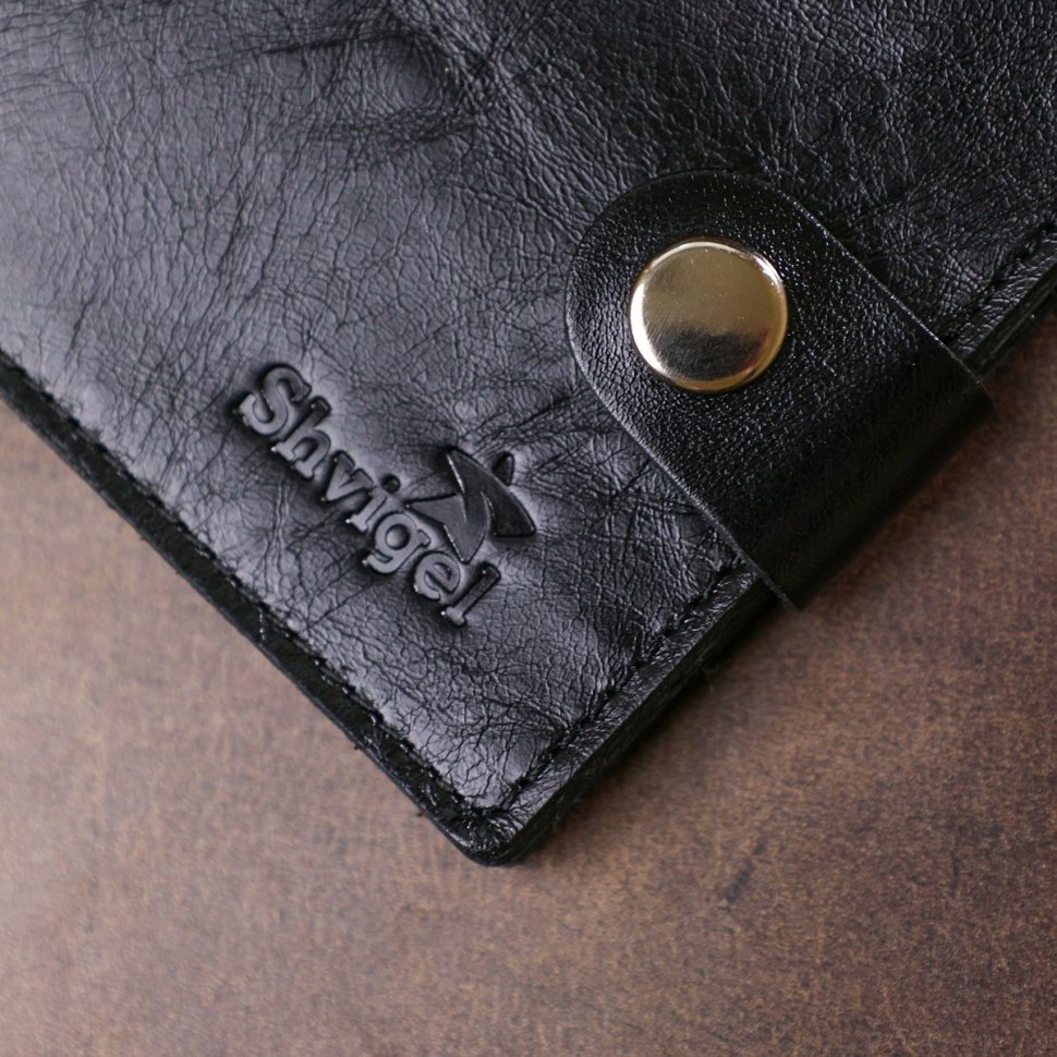 Чорне шкіряне чоловіче портмоне з фіксацією на хлястик та кнопку Shvigel (2416460)